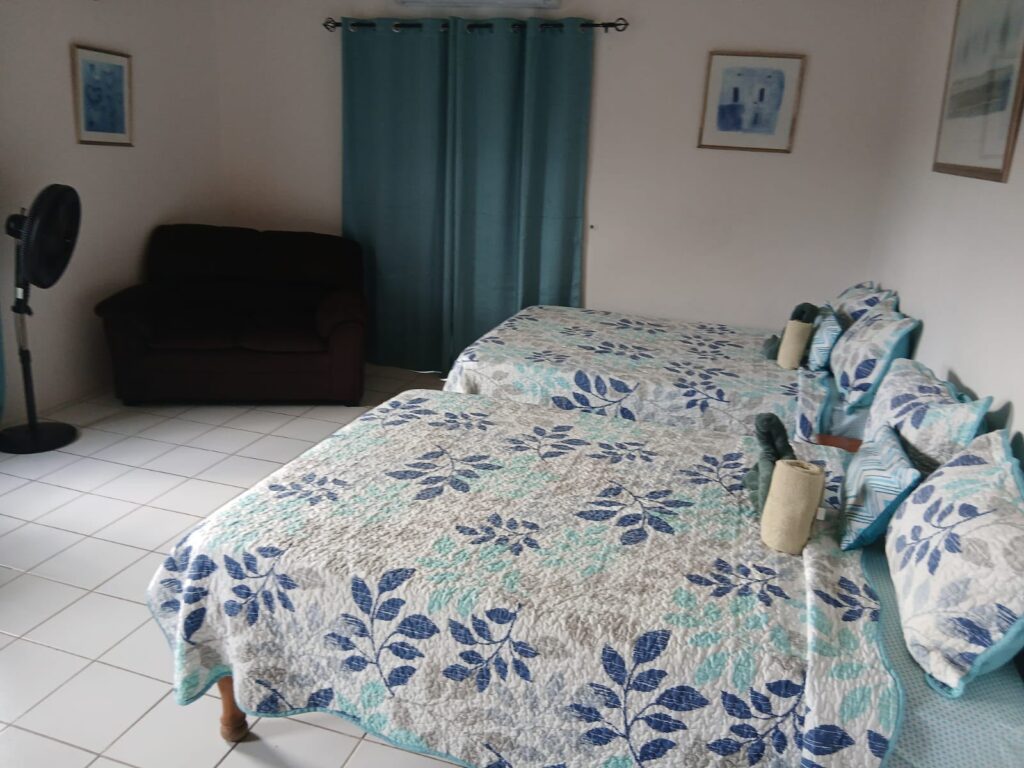 Bona Villa, Bon Accord, Tobago: a double bedroom with an armchair and air conditioning.