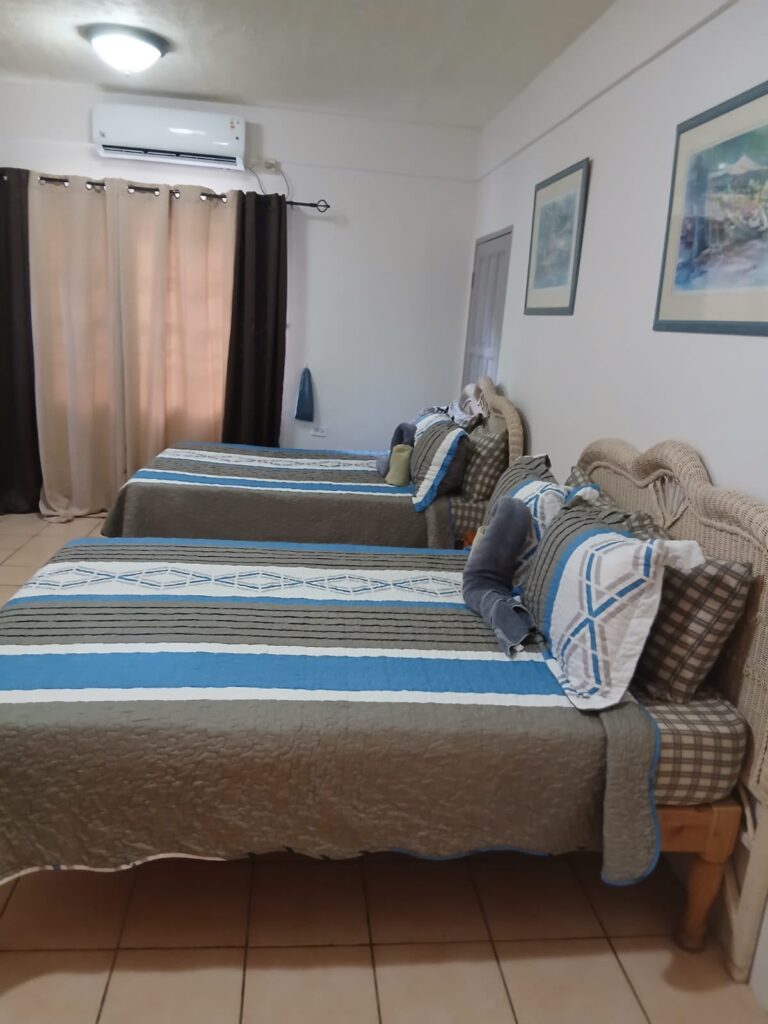 Bona Villa, Bon Accord, Tobago: a bedroom with two double beds and air conditioning.